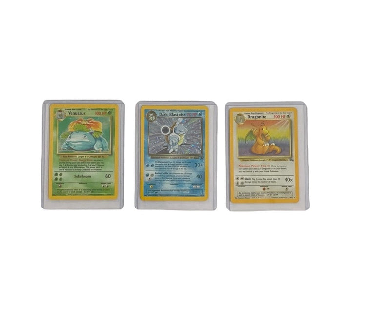 Tre Pokémon-kort: Blastoise fra Team Rocket, Venusaur fra Base Set, og Dragonite fra Fossil Set i plastiklommer, brugt som stock billede for udvalgte produkter hos CollexyLux.